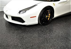 White sports car on a black full flake epoxy and polyaspartic garage floor.