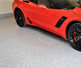 Red sports car on a full-flake mica-infused epoxy polyaspartic coated garage floor.